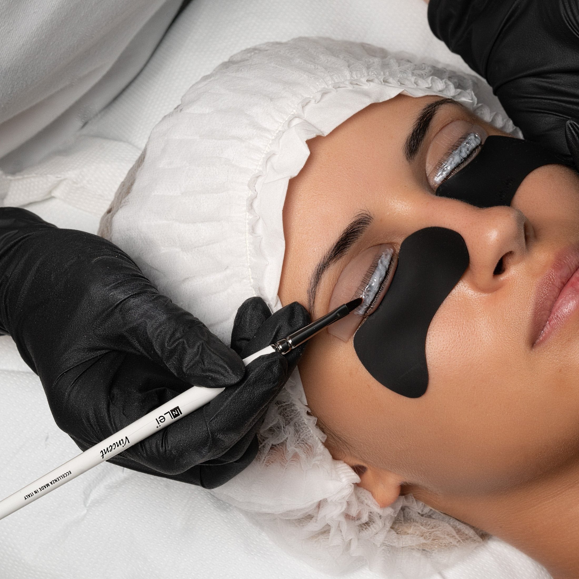 InLei-pensel legger produkt på vippene under en Lash Filler 25.9-behandling